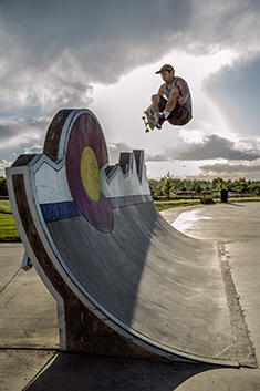 Skateboarder on a skateboard ramp at a skateboard park.